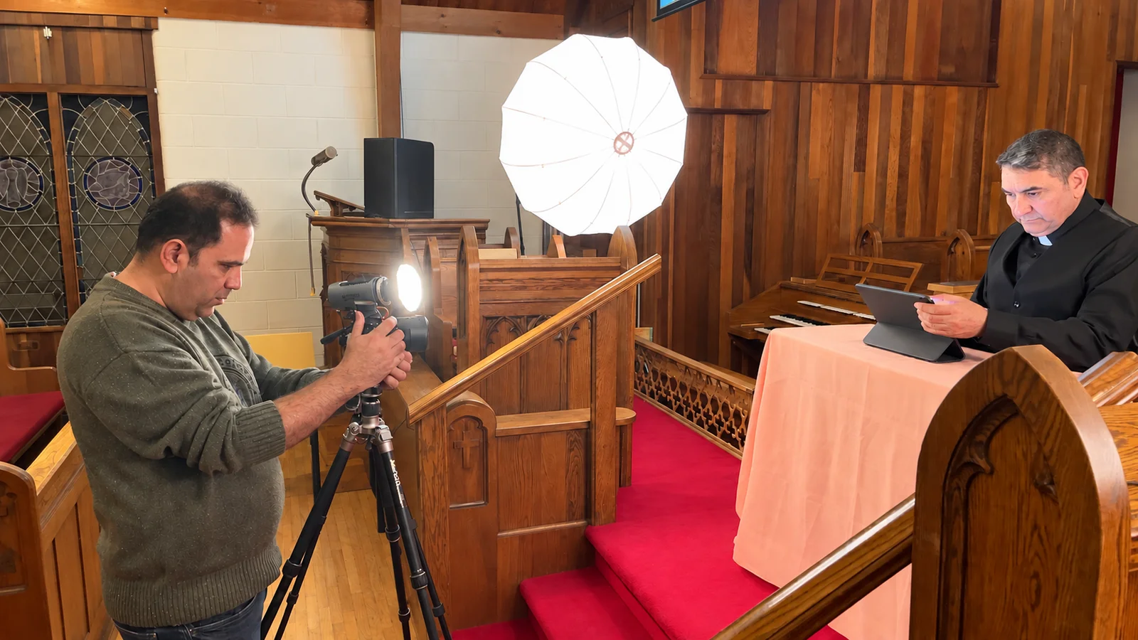 Filming with a tripod-mounted camera and lighting at the church