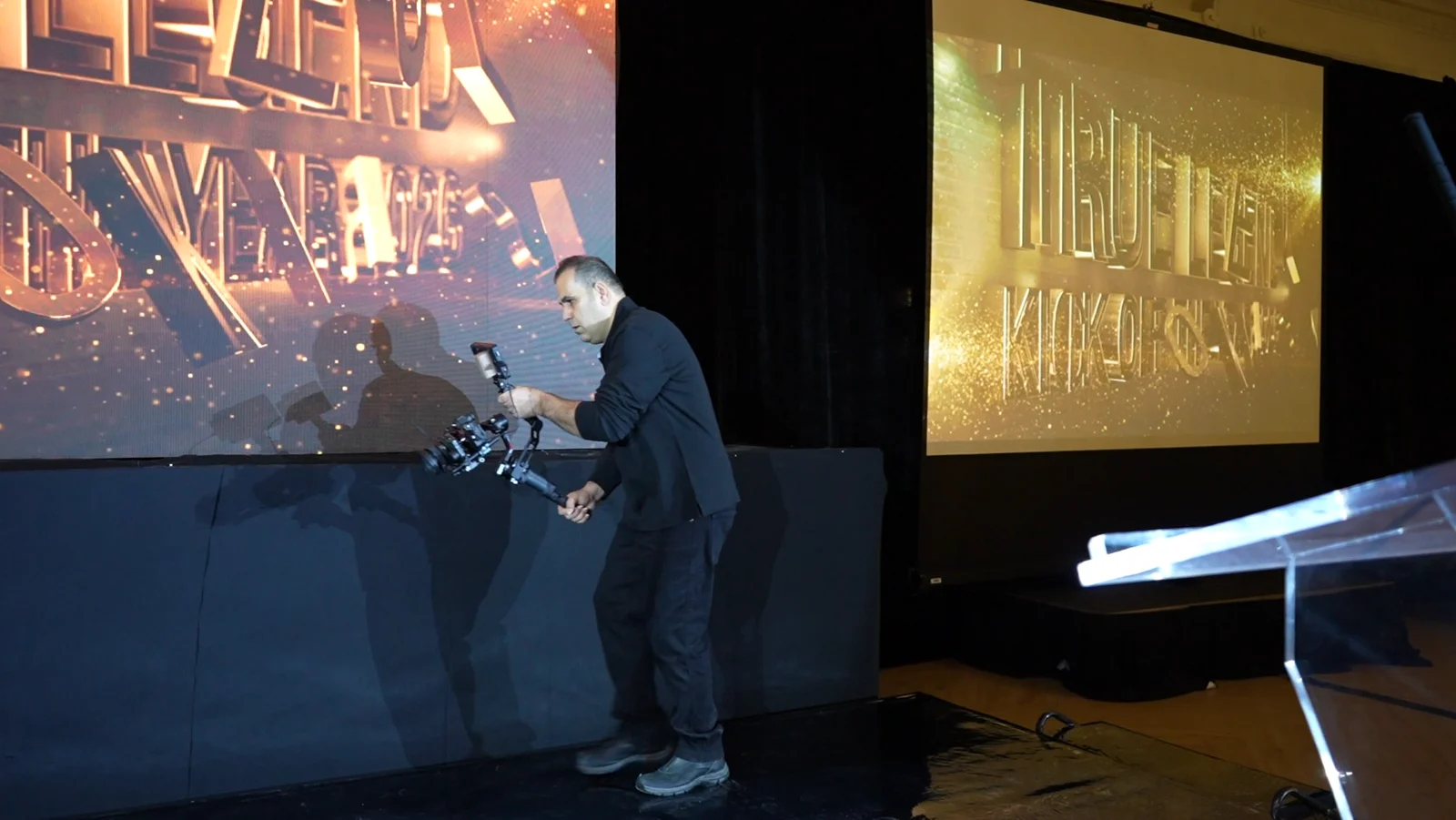 Wide view of the camera operator filming beside the stage