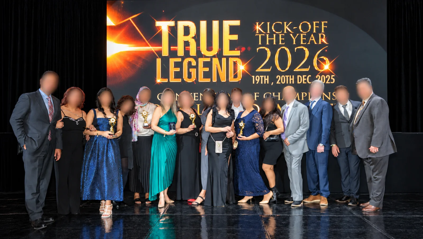 Group with awards in front of the kickoff screen, faces blurred