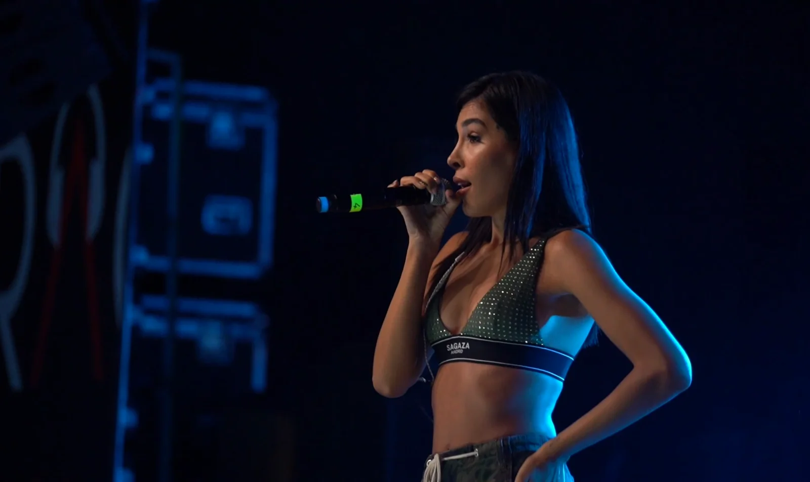 Performer singing under blue stage lighting