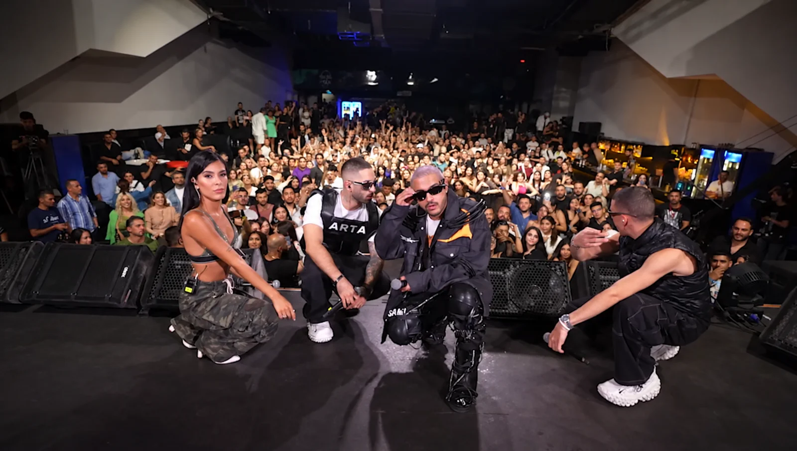 Performers posing on stage in front of the concert audience